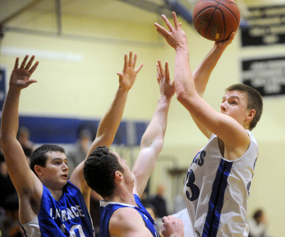 Erskine junior Noah Bonsant puts up a shot over Lawrence defenders during a Jan. 6 Kennebec Valley Athletic Conference Class A game in South China.