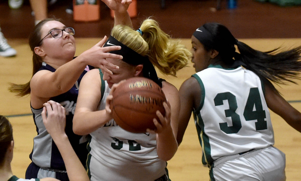 Temple's Olivia Baker, middle, looks to pass the ball as Highview Christian's Kelsi Upham, left, defends during a Class D South game Friday afternoon in Waterville.