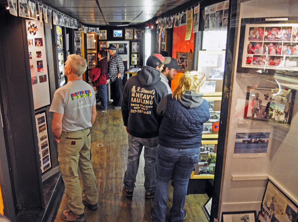 Staff photo by Joe Phelan 
 People look at displays in the Maine Motorsports Mobile Museum during the Northeast Motorsports Expo on Saturday at the Augusta Civic Center.