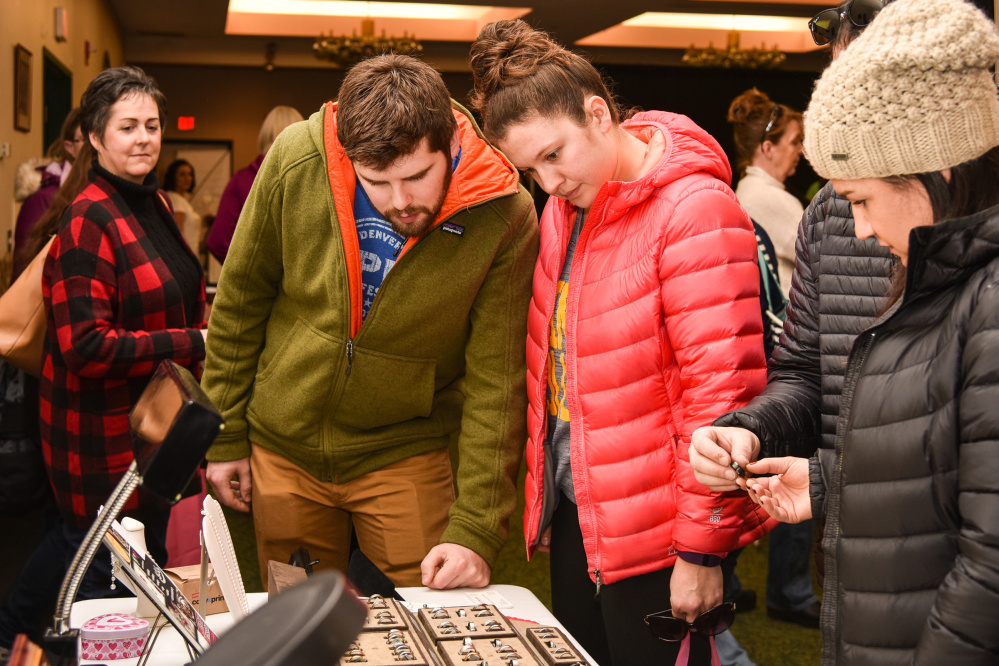 Dan Green, center left, and his fiancee, Jen Gifford, center, originally of Readfield, look at wedding rings Sunday while attending the Bridal Expo at the Augusta Civic Center on Sunday. While the couple resides in Sutton, Massachusetts, they are planning a September wedding in Maine.