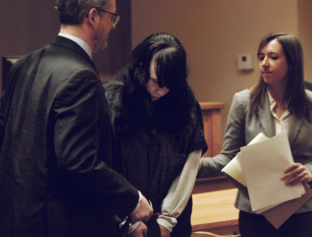 Miranda Hopkins, of Troy, is flanked Tuesday by defense attorneys in Belfast District Court after an initial appearance on a charge of murder in connection with the death of her 7-week-old son.