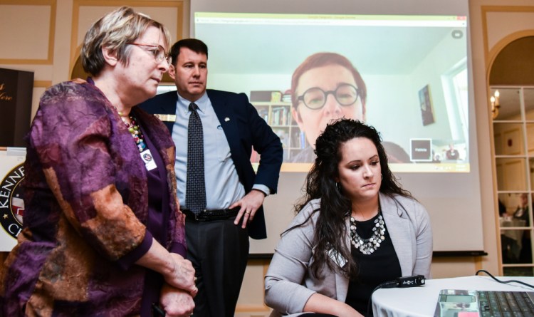 Karen Tucker, left, of Healthy Communities of the Capital Area, in Gardiner, asks a question Wednesday about labeling and regulation of marijuana to Kennebec Valley Chamber of Commerce guest speaker Patricia Rosi, background on screen, of Wellness Connection of Maine. Rosi is CEO of an organization that provides education on medical marijuana and operates medical cannabis dispensaries around Maine. Chamber board member Andrew Silsby, second from left, and Chamber Program Director Katie Doherty, right, assist with the remote connection.