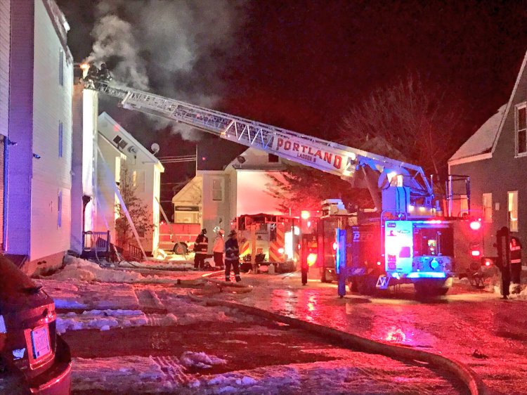 Firefighters extinguish a blaze at an apartment building on Munjoy Hill in Portland on Monday night.