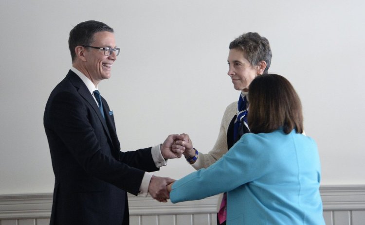 The University of New England's next president, Dr. James Herbert, greets presidential search committee Chairwoman Gloria Pinza and current UNE President Danielle Ripich after Tuesday's news conference in Portland. "James is a delightful person who has demonstrated a tremendous work ethic, a warm and engaging personality and a good sense of humor," Pinza said.