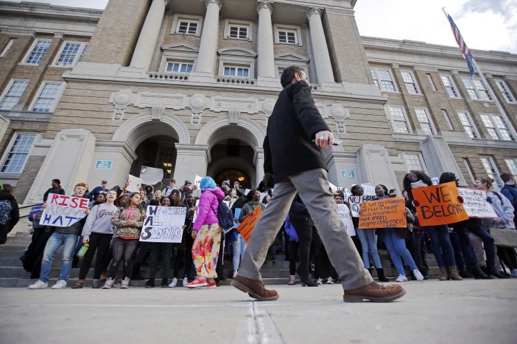 Portland Superintendent Xavier Botana awaits the arrival of more students on the steps of Portland High School on Friday afternoon during a protest march in response to an incident in which a Portland man has been charged with a hate crime for allegedly accosting a group of black students as they waited for a bus outside Casco Bay High School. About 200 students from Portland High School and Baxter Academy participated in the march around the school grounds. A similar event was held simultaneously at Deering High School. 