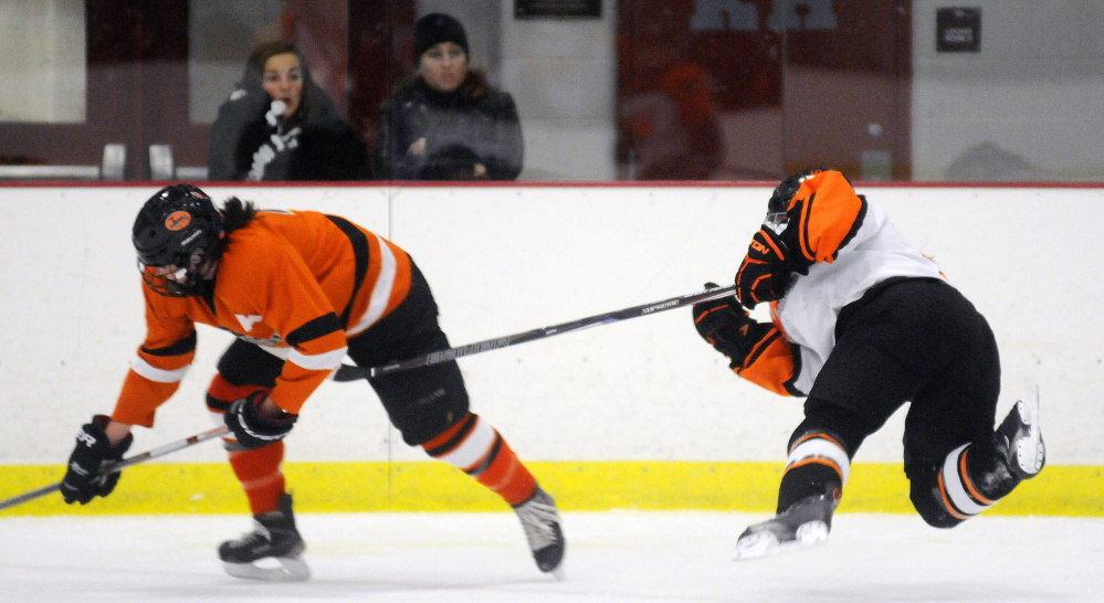 Winslow/Gardiner forward Gabby Hebert, right, slashes Brunswick's Beth Labbe during a game earlier this season at Kents Hill. The two teams meet again tonight in a playoff game.