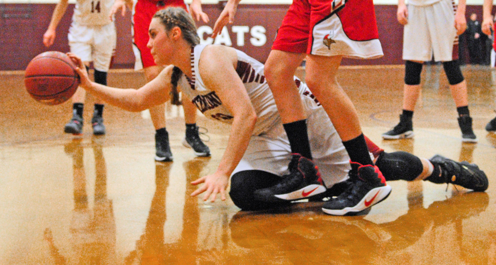 After diving to control a loose ball, Richmond's Sydney Tilton passes to a teammate during a game at Richmond High School.