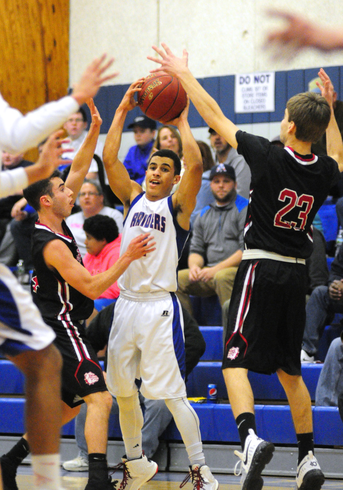 Oak Hill's Evan Boston, middle, gets double-teamed by Hall-Dale defenders Tyler Nadeau, left, and Ashtyn Abbot, during a game last month in Wales.