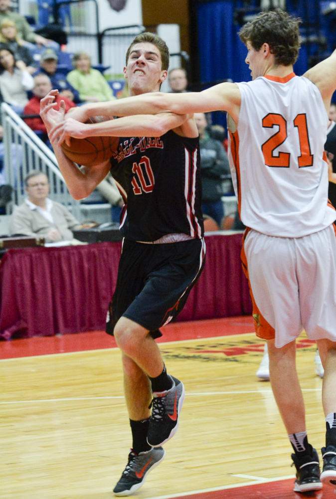 NYA's Jake Malcom (21) gets his hand on the ball as Hall-Dale's Alec Byron goes up for a shot during the first quarter of a Class C South quarterfinal game Monday at the Augusta Civic Center. The shot went wild, but the Bulldogs ended the quarter with a lead.