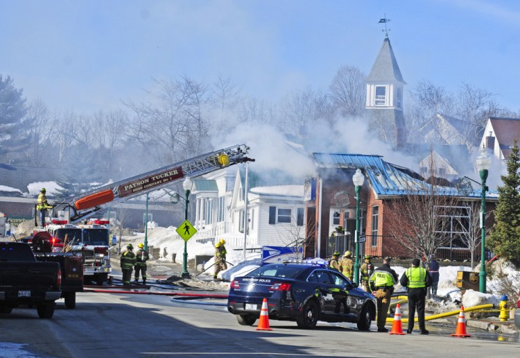 Firefighters work on Feb. 21 at the Winthrop post office, trying to quell the fire in the building that will now have to be demolished.