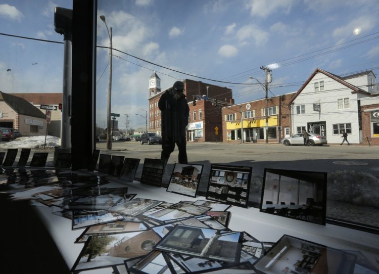 A man walks along a sidewalk on Forest Avenue outside the Speedwell Projects contemporary art gallery where small photographic prints fill a window display area. Artists are leading a Forest Avenue renaissance with the new contemporary art gallery, the return to Portland of a longstanding photography co-op and the emergence of a black box theater that is popular with theater groups and dancers. 