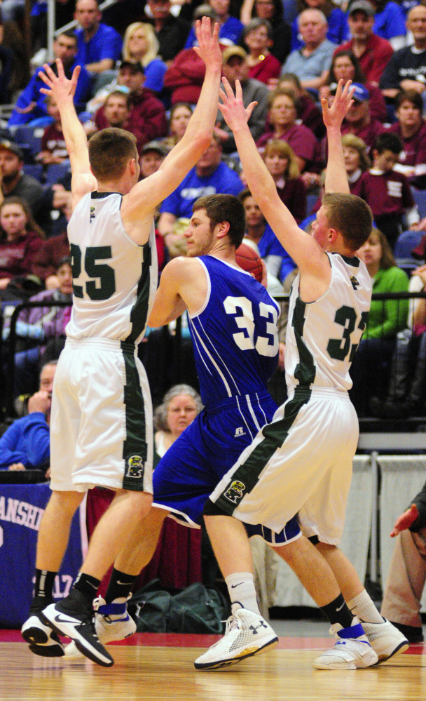 Madison's Mitchell Jarvais (33) gets double teamed by Winthrop defenders Garrett Tsouprake, left, and Nate LeBlanc in the Class C South championship game on Saturday at the Augusta Civic Center.