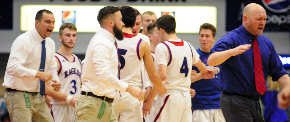 Messalonskee coaches and players celebrate at the end of regulation after rallying to tie up the Class A North semifinal against Skowhegan. It propelled the Eagles to their first regional championship.