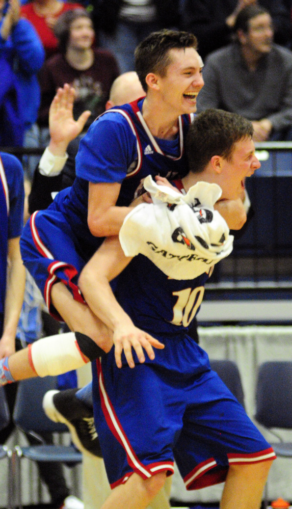 Messalonskee's James Kouletsis and Nate Violette celebrate after they defeated Oceanside 61-40 in the Class A North championship game Friday at the Augusta Civic Center.