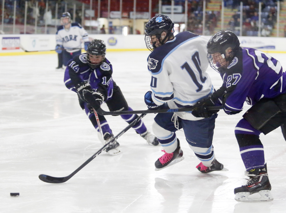 Dalton McCann of York skates between Waterville's Michael Bolduc, left, and Chase Wheeler in the second period of the Class B state championship game Saturday at the Androscoggin Bank Colisee in Lewiston.