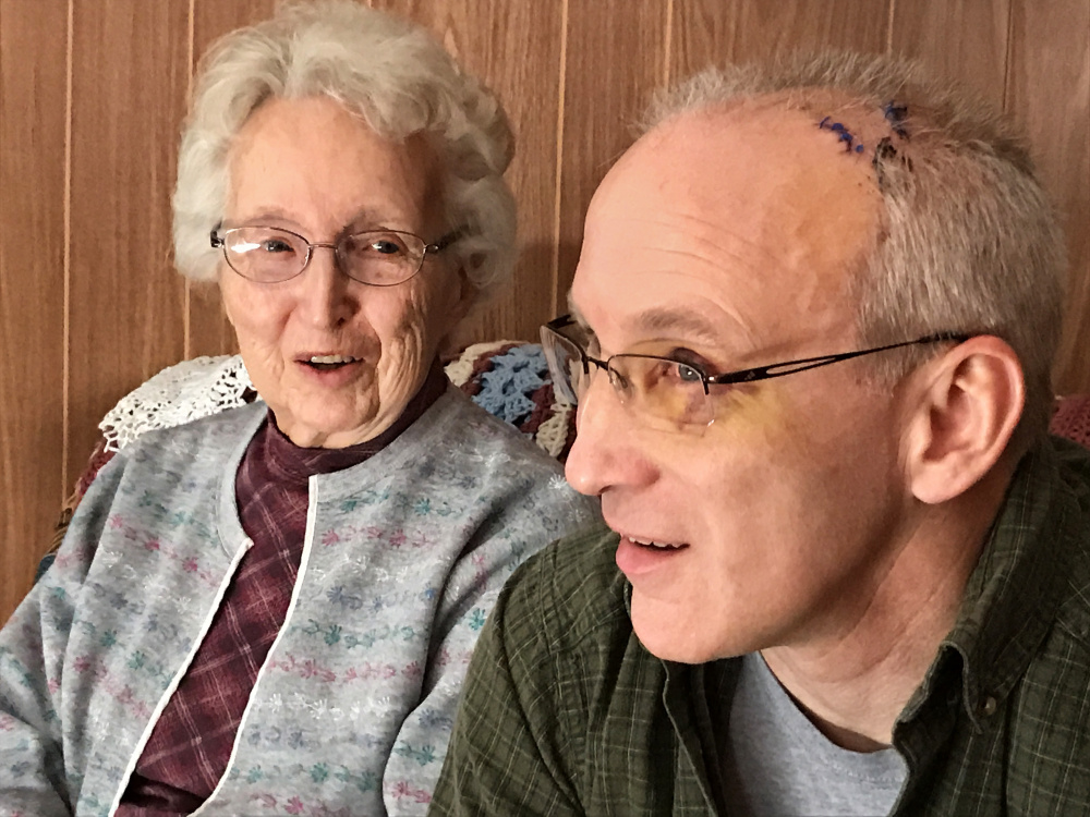 Audrey Hewitt looks over at her son Eric Hewitt as they explain, during an interview Friday in Audrey Hewitt's Sidney home, how he saved her during a home invasion. Eric Hewett suffered a concussion and a skull fracture, among other injuries.