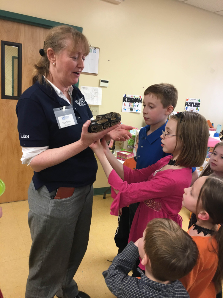 Lisa Smith, left, shelter director at the Humane Society Waterville Area, shows off Fluffy the Python to Keenan Sodoma, 13, Haylee Sodoma, 13, Vienna Sodoma, 7, and Brennan Sodoma, 5, as party guest Caelyn Berube, far right, looks on.