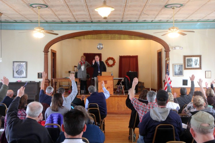Moderator John Bernier counts a vote March 11 to continue a discussion of Article 10 to authorize the Board of Selectmen to join the Maine Municipal Employees Health Trust at the Benton Town Meeting.