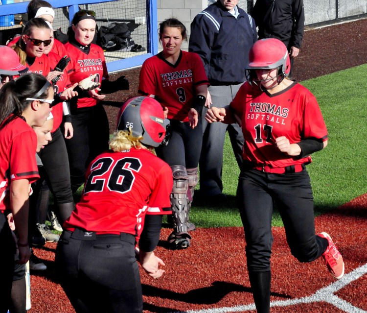Thomas' Korrie Laren touches home plate as teammates congratulate her after she hit a home run against Coby on Thursday in Waterville. The run was the only one scored in the game as the Terriers won 1-0.