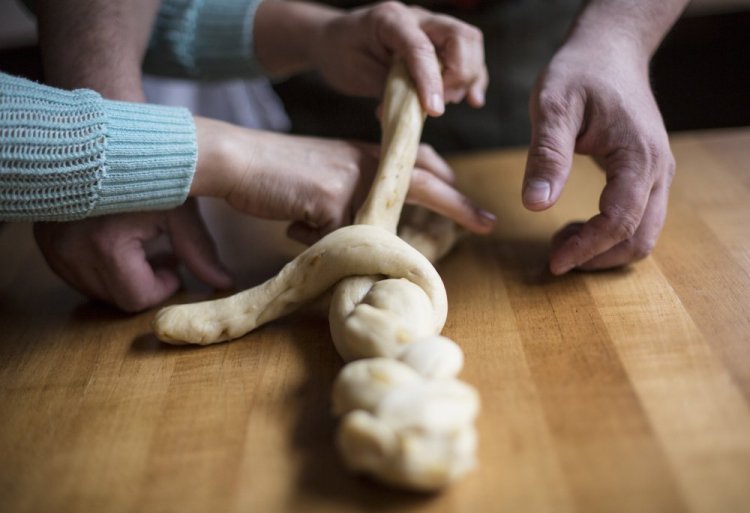 Ilma Lopez and Damian Sansonetti, owners of Piccolo restaurant and husband and wife, braid Easter bread dough.