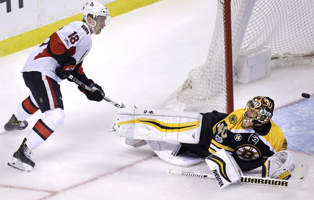 Bruins goalie Tuukka Rask (40) looks up at Ottawa Senators center Ryan Dzingel (18) as the puck flies through the crease during the first period.