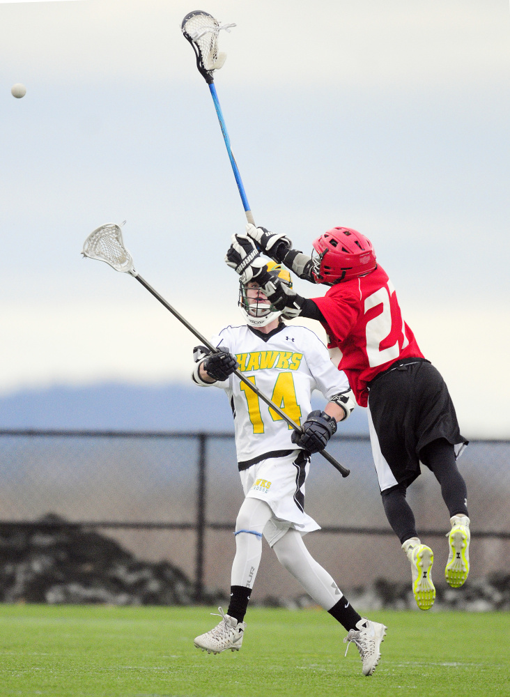 Maranacook/Winthrop's Jacob Sousa (14) passes around Cony's Zach Whitney on Thursday in Kents Hill.