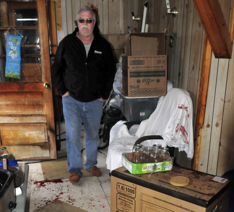 On Thursday, David Grant surveys the enclosed porch and breezeway in his neighbors' home at 230 Oak St. in Oakland, where blood was splattered on the floor and the walls. Jeremy Clement allegedly entered the home Wednesday evening and shot Jasmine Caret before her mother, Roseanna Caret, subdued Clement with a bat and then police arrived and arrested him. Grant assisted police in the arrest.