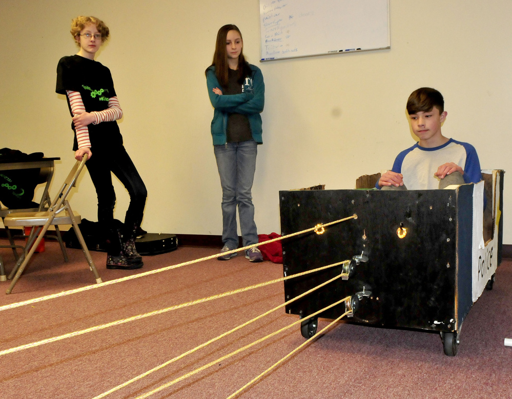 Home-schooled student members of the Somerset Homeschool Co-op demonstrate pulling a vehicle with student Ashton Umbrianna inside while showing off their team Infinite Velocity entry that earned them a state championship in an academic challenge competition Wednesday. They will compete for a national title in Tennessee. Sarah Hatfield, left, and Mackenzie Merrill watch the demonstration.