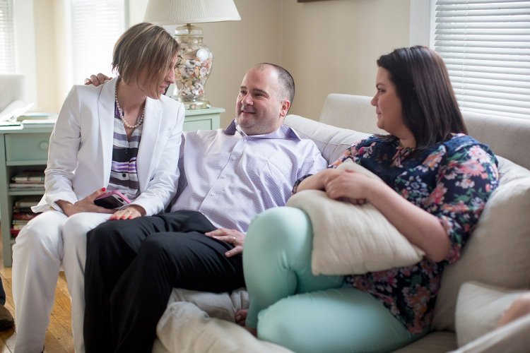 Anthony Sanborn sits on the couch at the home of his friend Lisa Alexander with his wife, Michelle Sanborn, left, and his daughter, Santana Levier, about an hour after leaving the Cumberland County Jail.