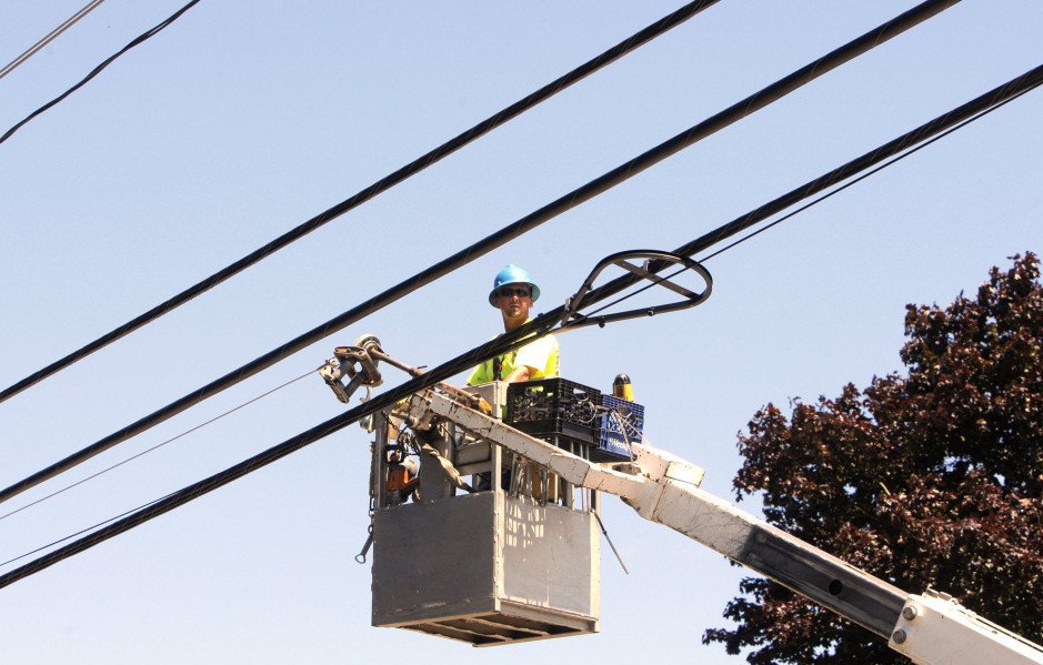 Ericson Estes of NextGen runs a line to support fiber-optic cable along Route 1 in Wells in 2012.