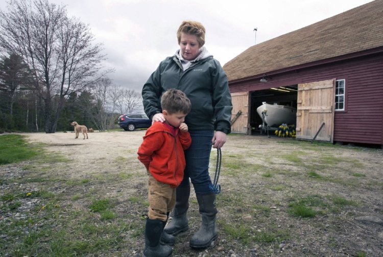 Elizabeth Harmon, who lobsters for a living, comforts her son Orin at their Brooksville home last week. Without Medicaid and Consumers for Affordable Healthcare, Harmon thinks her son, who was born with a heart defect, wouldn't be alive, and she and her family would be bankrupt.