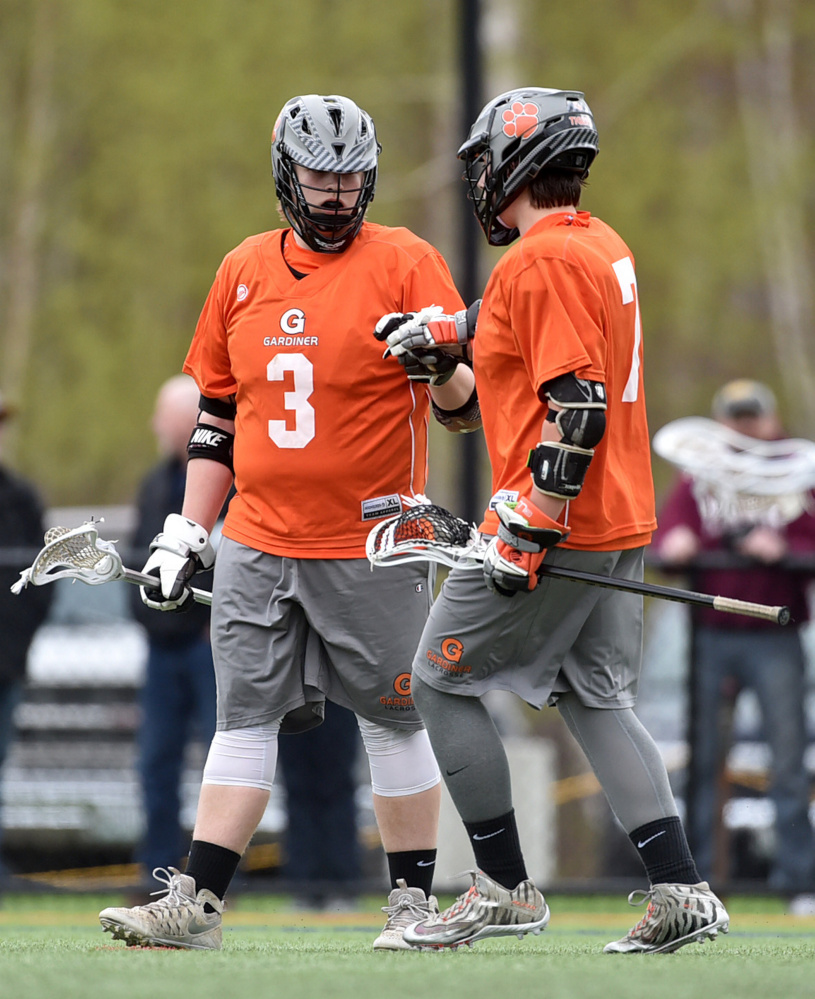 Gardiner High School's Mike Poirier (3) celebrates a third-period goal with teammate Tristan Hebert against Winslow High school at Thomas College in Waterville on Tuesday.