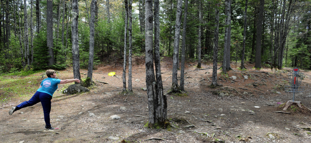 Staff photo by Joe Phelan 
 Cathy McDevitt takes a long putt toward the basket on Saturday during the Farmers Daughters Open at CR Farm Disc Golf in West Gardiner.