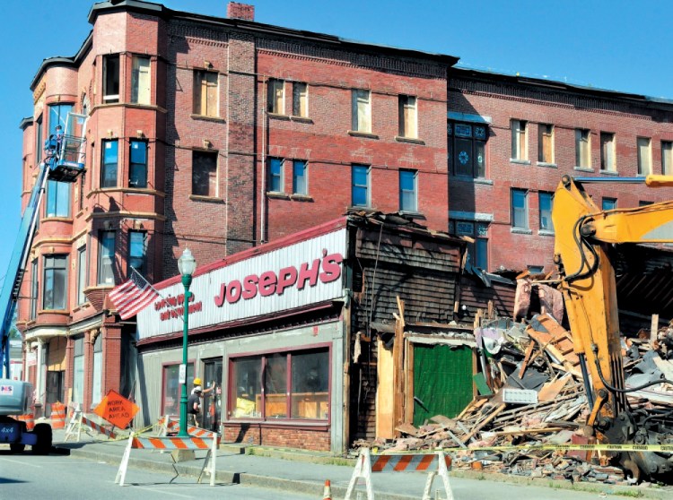 Crews tear down the former Joseph's Sporting Goods store as workers restore the Gerald Hotel on Main Street in Fairfield on June 20, 2013. A potential business has backed off developing the site, though some 13,000 cars pass through the area daily.
