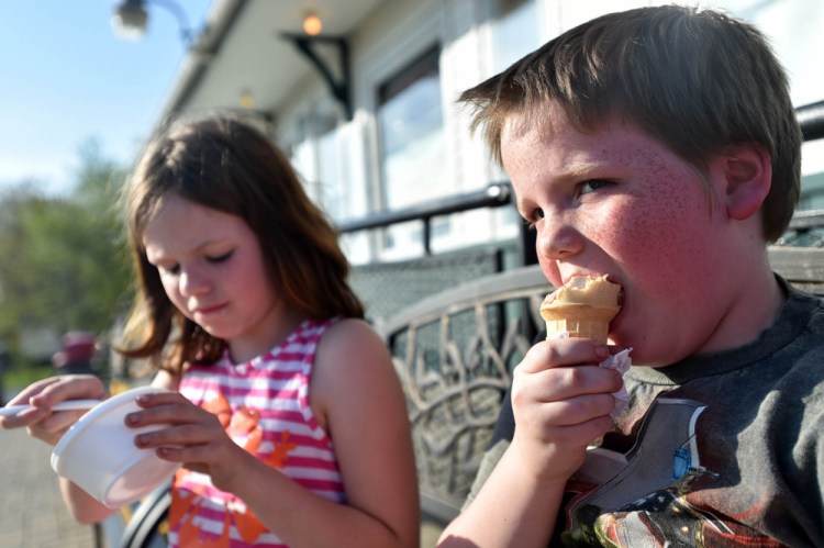 Benjamin  Finnimore, 9, right, prefers his ice cream in a cone whereas his sister Melissa prefers it in a dish on hot days at the North Street Dairy Cone in Waterville on Thursday. The temperature recorded at the Waterville airport hit 91 degrees Thursday, beating the previous record of 88 degrees in 1977.