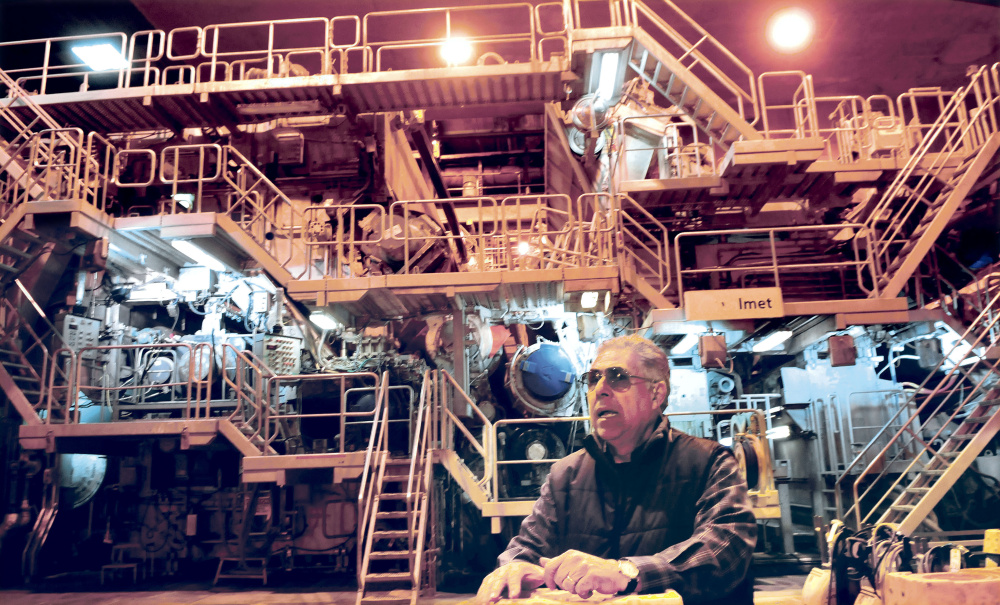 Jaime Broce of Somerset Acquisition LLC and current manager of the former Madison Paper Industries mill stands April 20, 2017, in front of the Number 3 paper making machine that is being sold via private negotiation while other mill assets will be sold at auction beginning June 13.