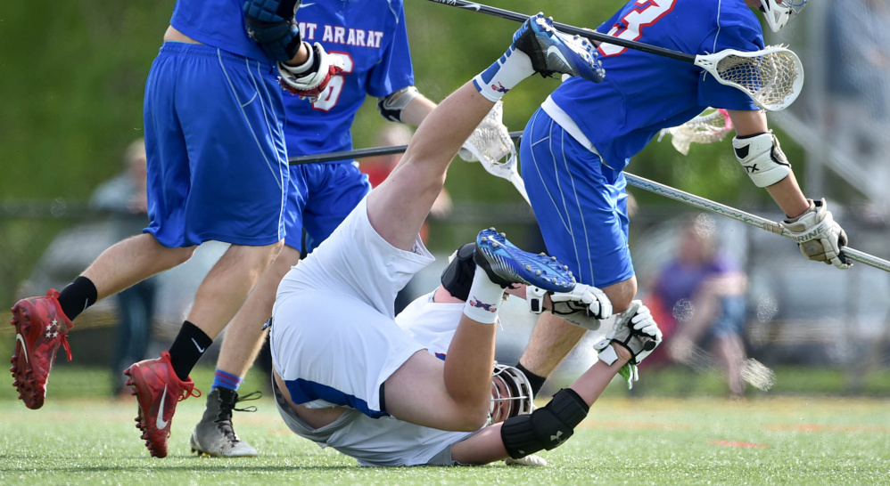 Messalonskee's Colin Kinney (20) gets knocked to the turf by a Mt. Ararat defender as Sean Roberts (3) picks up the loose ball in the first quarter of a game Tuesday at Thomas College.