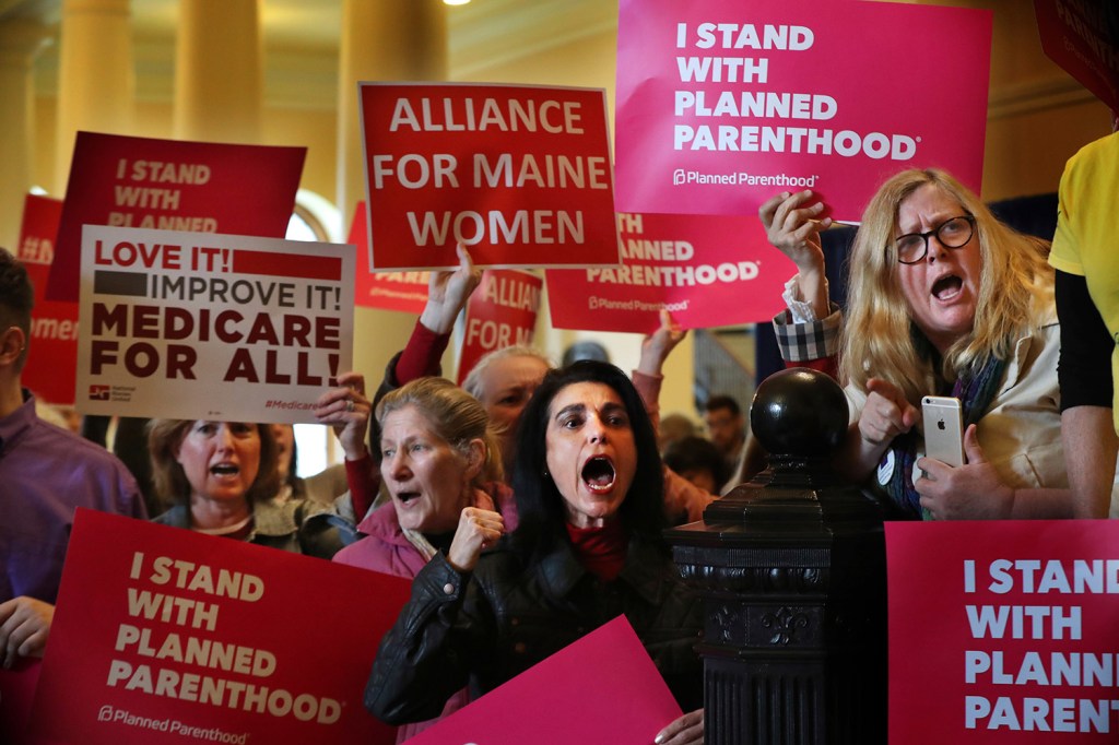 Jayne Hurley of Portland, center, and other protesters shout their opposition to the Trump administration's policies during Wednesday's visit to the Maine State House by Secretary of Health and Human Services Tom Price and Kellyanne Conway, an advisor to President Trump.