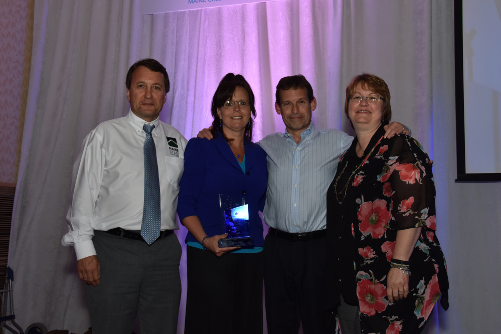 Stacey Dow, executive assistant at Maine State Credit Union, holds the Diane L. Oceretko People Helping People Award she received recently during the Maine Credit Union League's annual awards dinner. From left are Maine State CU's Tucker Cole, president and CEO; Dow; Mark Young, senior vice president and chief operating officer; and Angela Harvey, director of human resources.