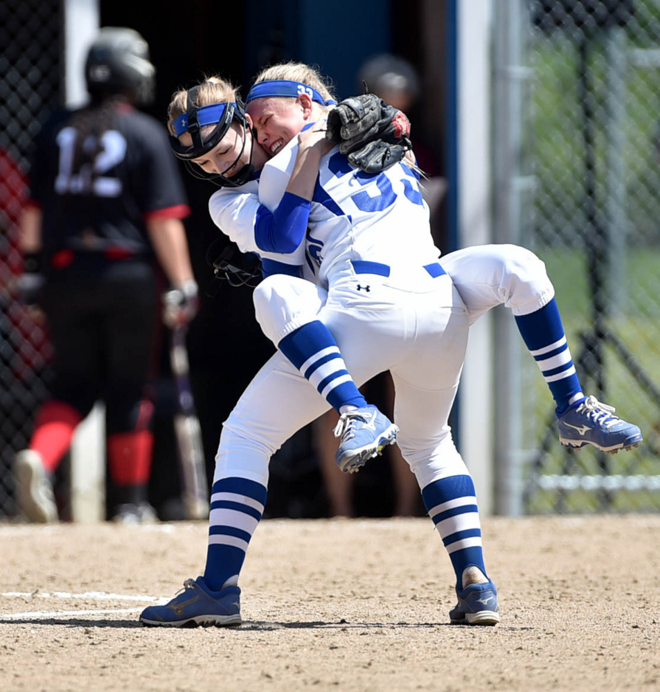 Madison pitcher Madeline Wood (33) holds teammate Whitney Bess in celebration after the Bulldogs defeated Lisbon 6-5 in a Class C South semifinal Saturday afternoon in Madison.