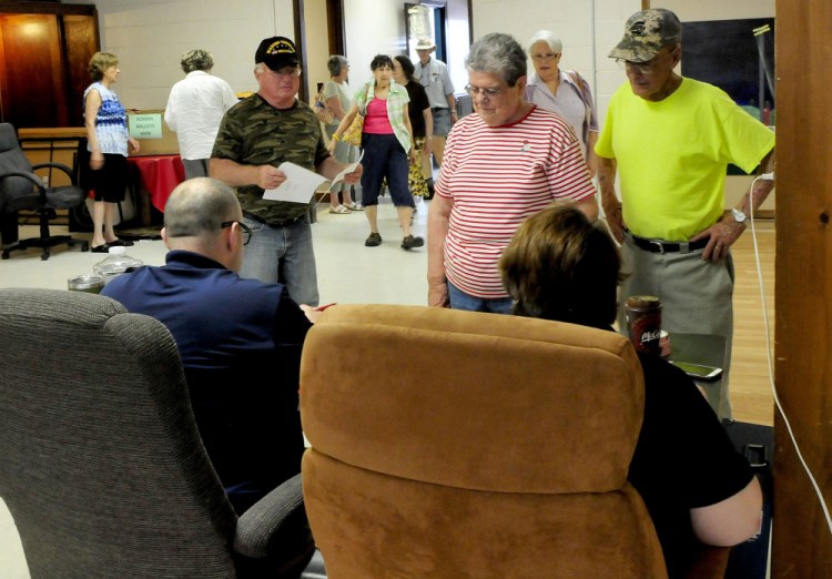 Farmington voters line up for ballots Tuesday at the Farmington Community Center. A ballot clerk said the voting was steady and a large turnout was expected. The Regional School Unit 9 budget was rejected, and the district now will revise the budget and put it out to voters again.