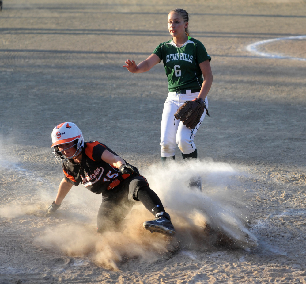 Skowhegan's Wylie Bedard scores on a wild pitch as Oxford Hills pitcher Lauren Merrill holds her hand up to stop the throw during the Class A North title game Wednesday night in Augusta.