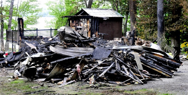 This cottage on Brickett Point Road on East Pond in Oakland was destroyed by fire Saturday. Neighbor Linda Cormier heard a popping noise that she believes were the windows exploding and when she went outside saw the home covered in fire.