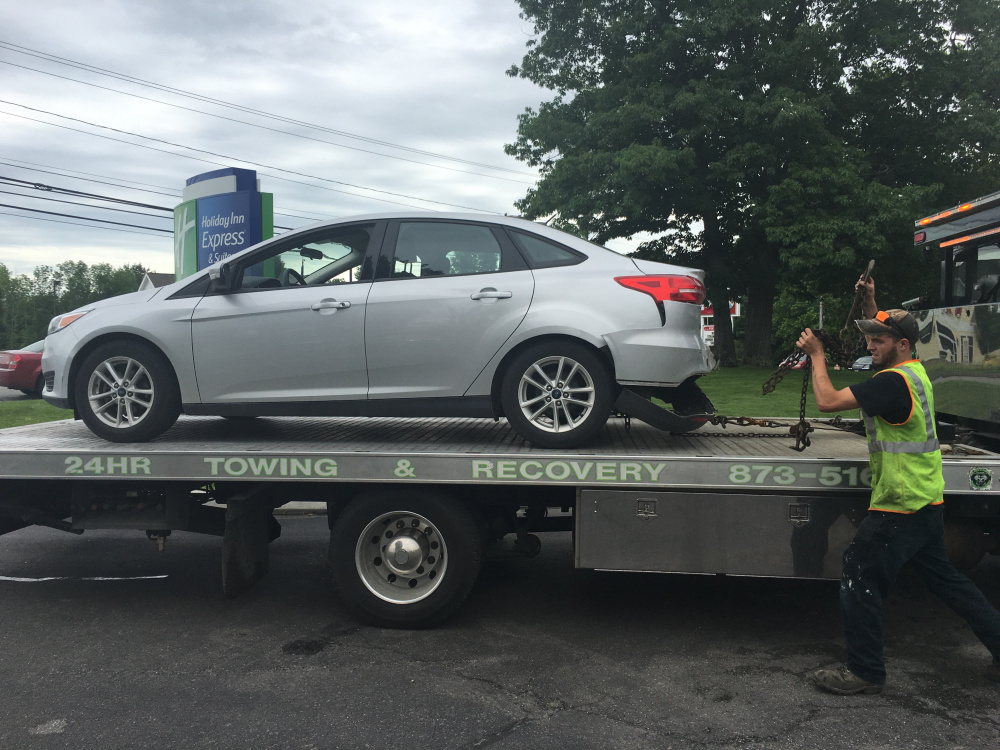 A tow truck removes one of two cars involved in a rear-end crash Saturday morning on upper Main Street in Waterville that, according to police, injured both drivers slightly.