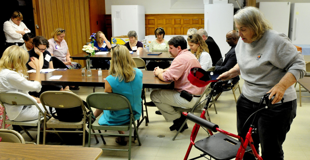 Sheila Branham, right, leads a prayer before lunch on Monday at the Sacred Heart Soup Kitchen in Waterville. In the group behind her are members of the EPA and state-run agencies who are touring Waterville facilities that contribute to a healthy environment.
