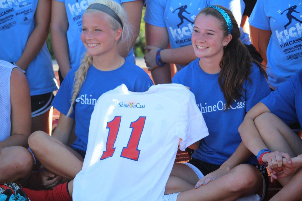 Katie Mercier, left, and Madisyn Charest, former Messalonskee Girls Soccer players, carry Cassidy Charette's jersey at last year's 11-hour soccer event "Kick Around the Clock for Cass." The second annual event is planned from 9 a.m. to 8 p.m. Sunday, July 16, at Thomas College.