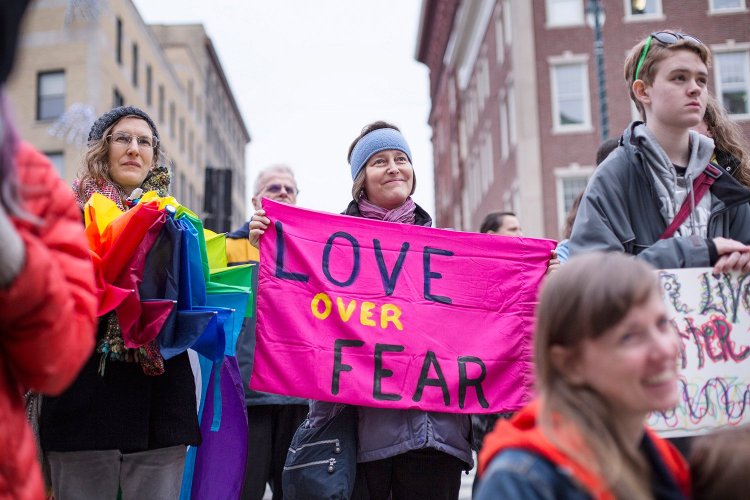 Michelle Fournier of Falmouth, center, and Oliah Fahrenwald of Portland, left, listen to a speaker at a March rally in support of transgender rights.