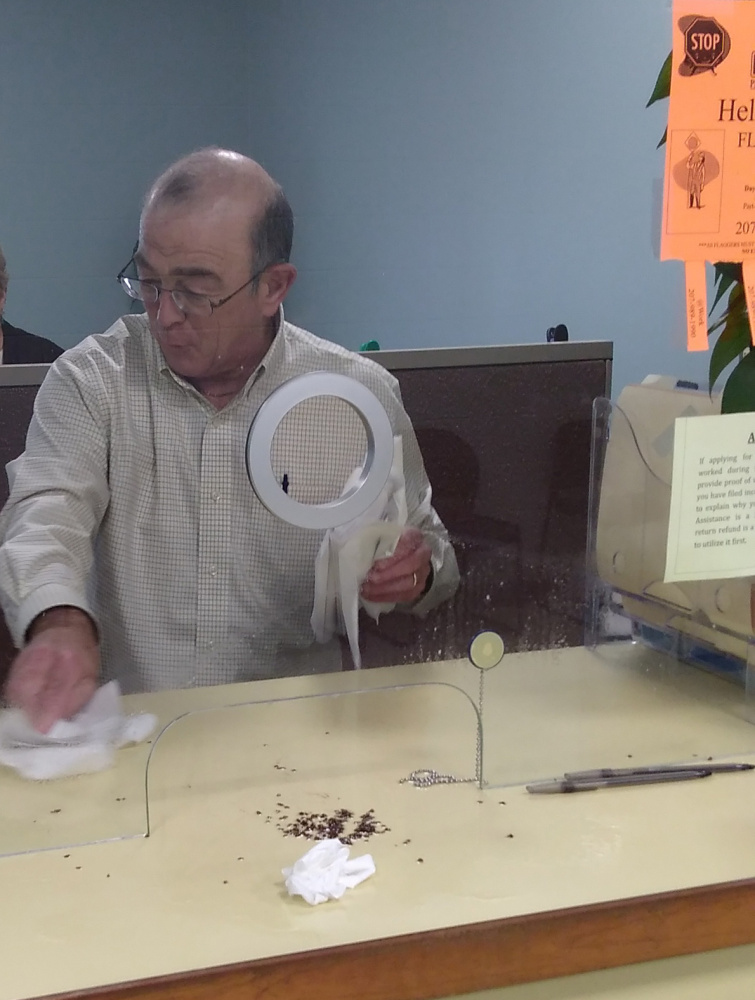 Ralph St. Pierre, Augusta's finance director and assistant city manager, picks up bedbugs that reportedly were spilled by a disgruntled man June 2 at Augusta City Center.