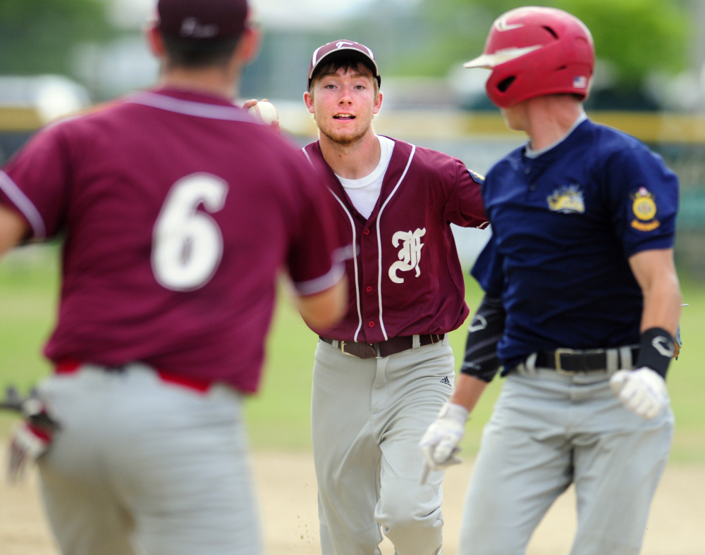 Franklin County first baseman Corey Rogers, left, and second baseman Tom Wing catch Augusta baserunner Taylor Heath in a rundown during a Zone 2 playoff game Tuesday at Morton Field in Augusta. Heath was tagged out sliding back into first.