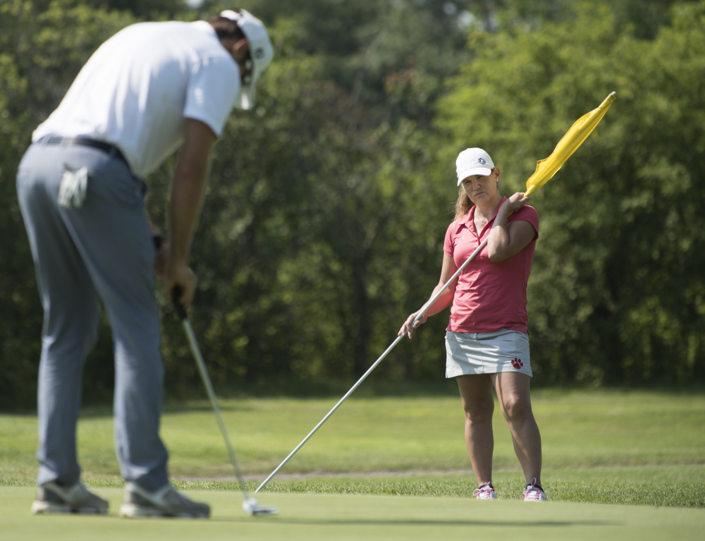 Kristin Ingram, right, of Monticello Arkansas caddies for her friend Matthew Baker, right, of Orlando, Florida on the 3rd hole of Bangor Municipal Golf Course on Friday.